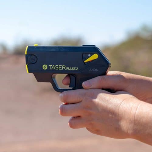 Person holding a Taser Pulse 2, showcasing features in an outdoor setting.