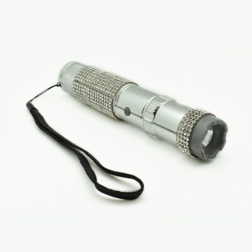 Silver flashlight with studded design and wrist strap on white background.