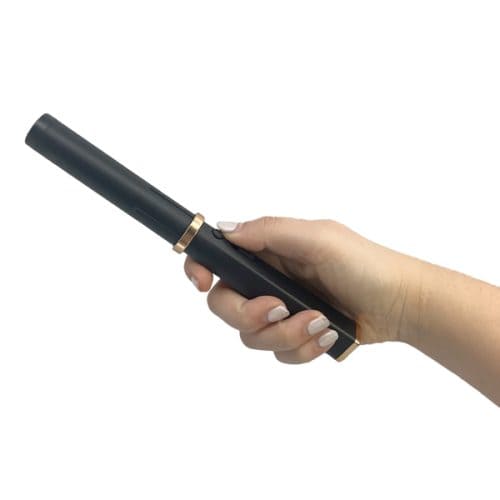 Hand holding a black curling wand with gold accents.