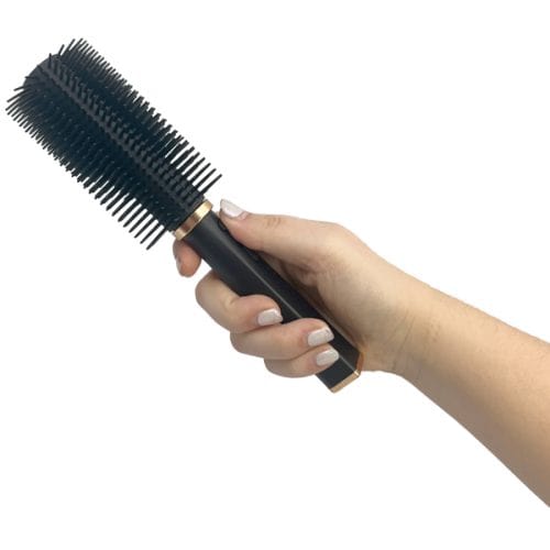 Hand holding a black round hairbrush with dense bristles, isolated on a white background. Ideal for styling and blow-drying.