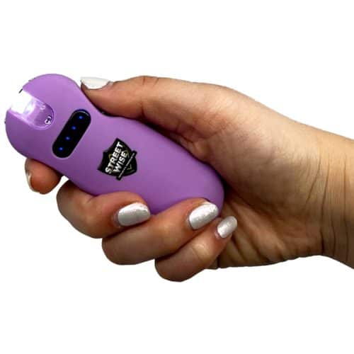 Hand holding a purple personal safety stun gun with Streetwise logo, displaying functional design for self-defense.