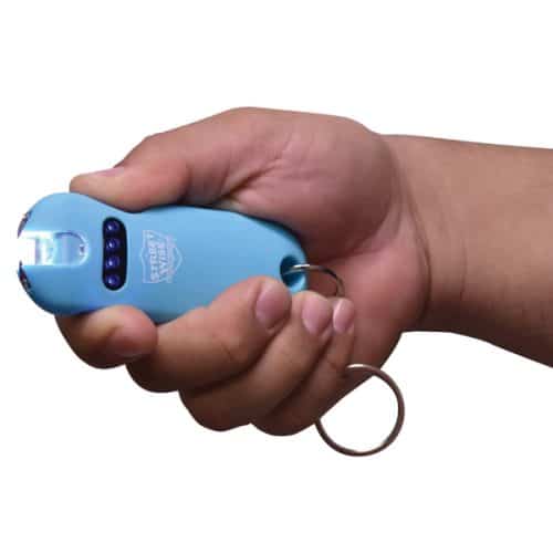 Hand holding blue stun gun with keyring, designed for self-defense and personal safety.