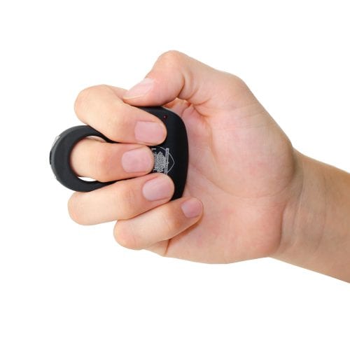 Hand gripping a black plastic hand exercise tool for muscle strength and stress relief.