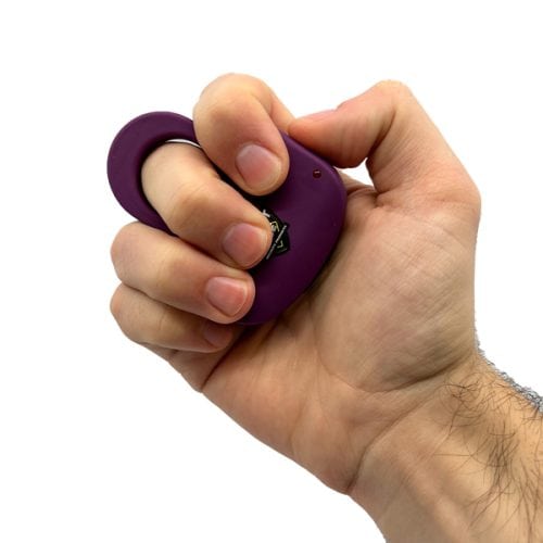 Hand gripping a purple safety tool with a built-in ring, showcasing its ergonomic design and user-friendly grip.