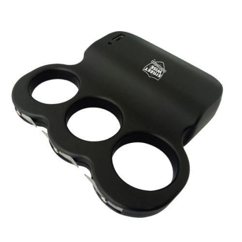 Black self-defense stun gun shaped like brass knuckles with three finger holes and a charging port.