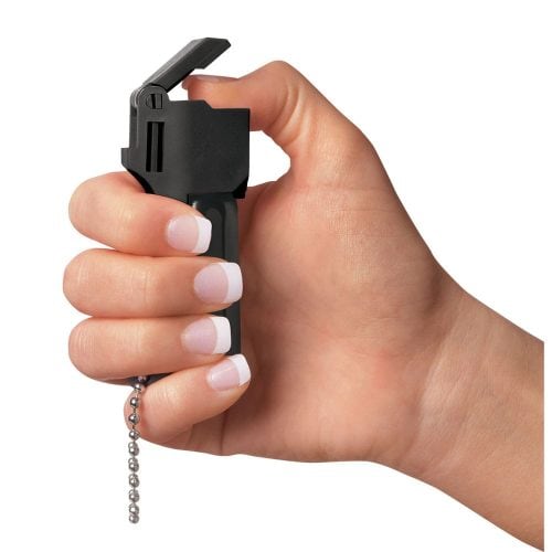 Hand holding a black safety device with a pull chain, ready for use.