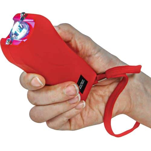 Red stun gun in hand showing bright electric current for self-defense.