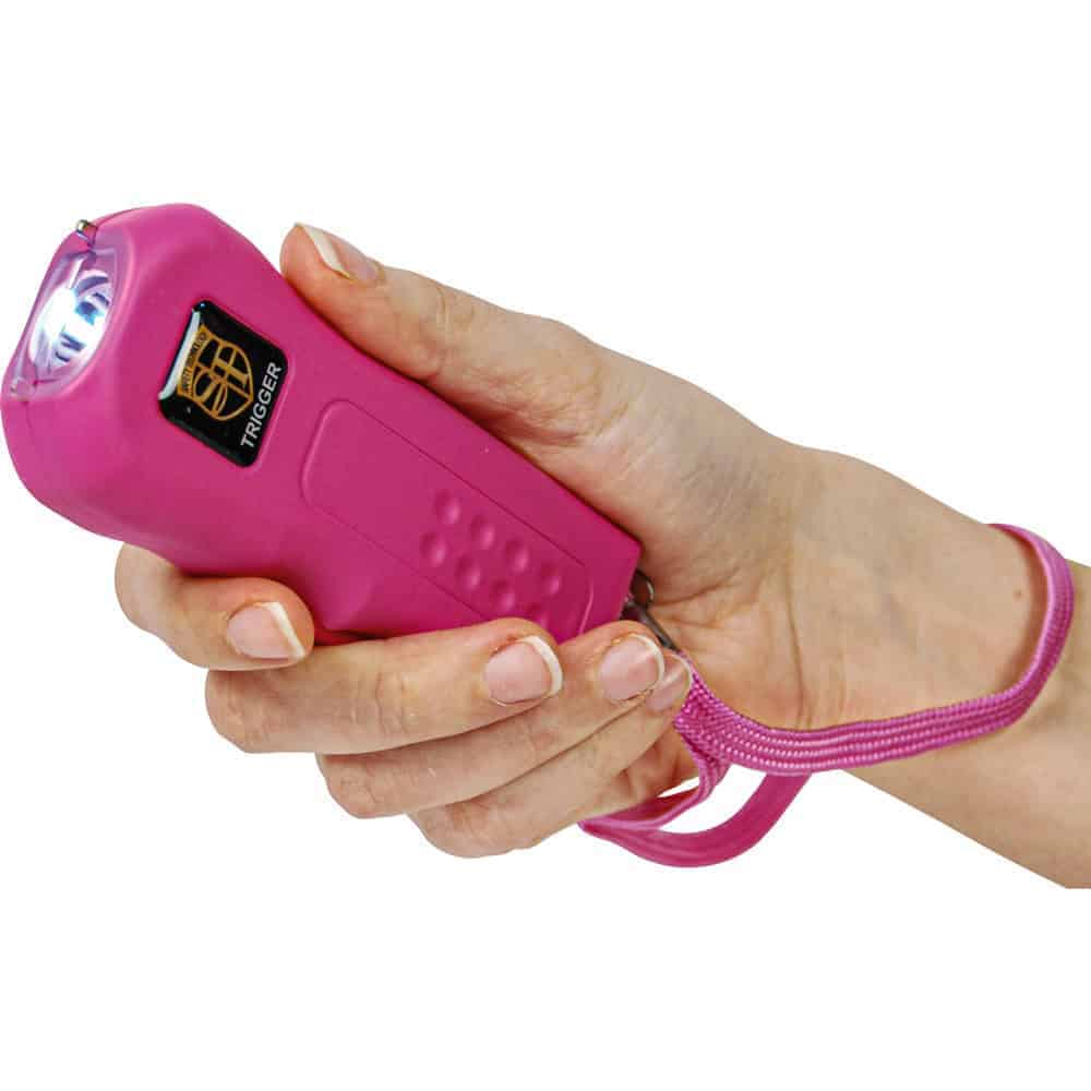 TRIGGER-PINK_ajpg | Para Bellum Defense Hand holding a pink stun gun with wrist strap, personal safety device in focus.
